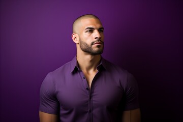 Wall Mural - Portrait of a handsome young man in purple shirt over purple background