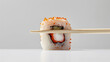 Elegant Sushi Roll Balanced on Bamboo Chopsticks Against Blue Background