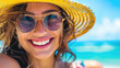 Smiling young attractive woman portrait wering sun glasses and hat on the beach