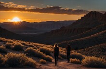 Two Hikers At Sunset In A Desert Area Resembling Utah Or Arizona. 