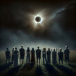 A group of people stands in a field, gazing up at a dramatic solar eclipse in a darkened sky 