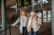 © Marko Geber - Two senior women walking together at the train station