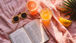 A summer reading flat lay featuring a novel sunglasses and a refreshing drink.
