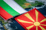 Fototapeta Zwierzęta - Bulgaria and Macedonia flags patches and country symbols on globe background, Close up, Concept of difficult mutual relations