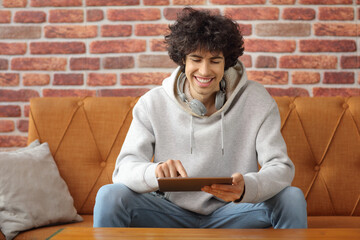 Sticker - Guy sitting on a sofa and using a digital tablet