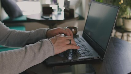 Close up of freelancer's developer hands typing program code on laptop keyboard in coworking. Businessman at work in working in office. Copywriter writing text on computer keyboard in coffeeshop.