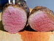 Smoked and grilled beef eye of round cut in half to show medium rare pink