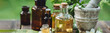 Herbal pure natural cosmetic ingredients on wooden background. Mix of holistic flowers and herbs, salt, massage herb-infused essential oil in glass bottles. Aromatherapy, fragrance production. Banner