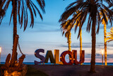 Fototapeta Natura - colorful letters of Salou town, palm trees andl beach at sunset, Catalonia, Spain