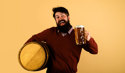 Wall Mural - Beer time. Happy brewer with wooden barrel and mug of beer. Bearded man tasting brewed beer in pub or bar. Oktoberfest festival. Germany traditions. Stylish handsome male drinking lager beer. Alcohol.