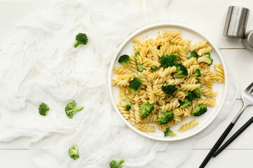 Wall Mural - Plate of tasty pasta with broccoli on white wooden background