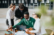 © qunica.com - Diverse team of business professionals discussing marketing strategies and profit growth while sitting at a coffee bar outdoors.