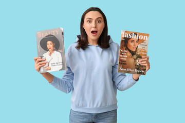 Poster - Surprised young woman with magazines on blue background