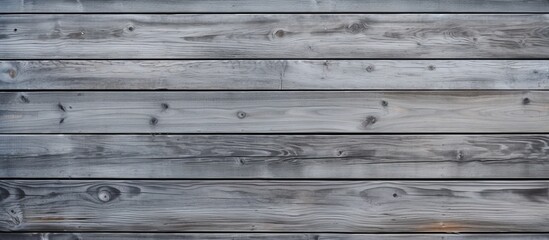 Poster - A closeup of a rectangular grey wooden wall with parallel siding planks, showcasing the hardwood texture and shades of grey