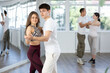 © JackF - Young couple learns to tango pair dance during dance class in studio, repeat movements and learn wedding dance. Studio school for amateur and professional dancers
