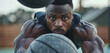 A fitness fanatic performs medicine ball smashes, his resolve seen in his face as he looks directly into the camera