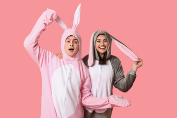 Sticker - Beautiful young couple in bunny costume on pink background. Easter celebration