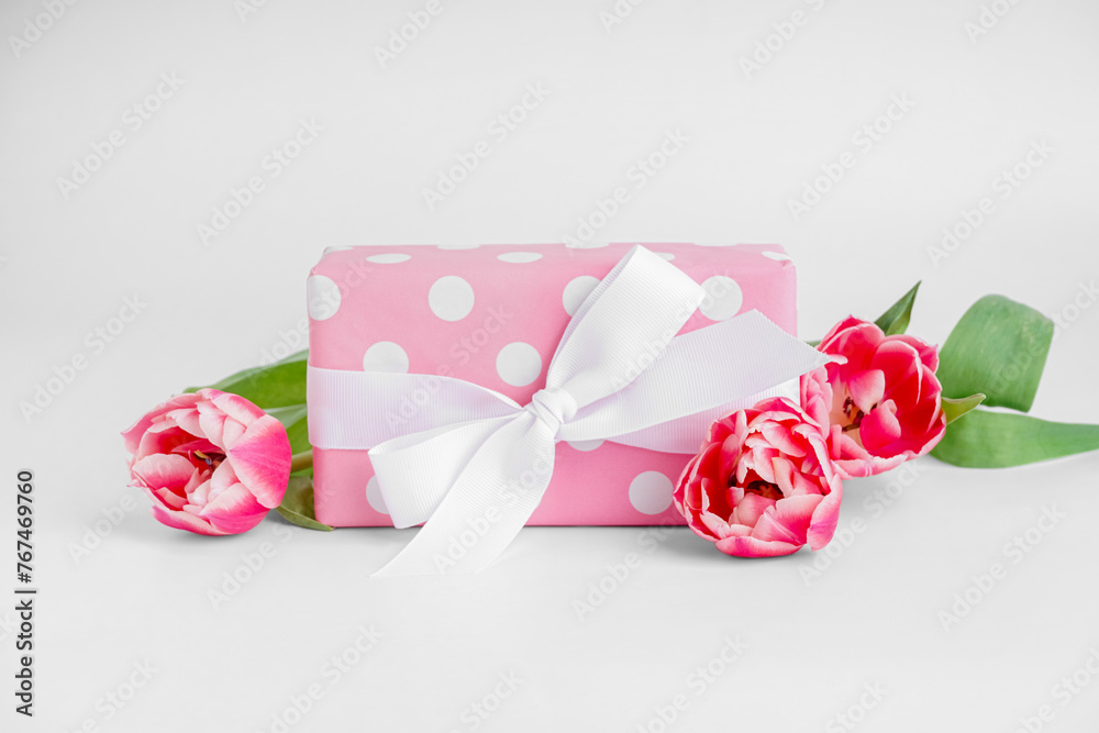 Gift box with beautiful tulip flowers on white background