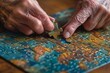 Elderly hands placing a puzzle piece into a nearly finished jigsaw puzzle