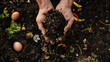 hands holding compost soil above a compost pile containing various decomposing organic materials.