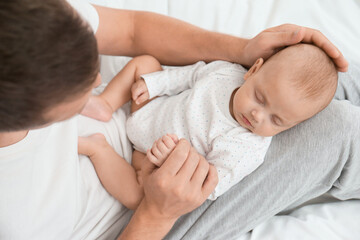 Wall Mural - Father with his cute sleeping baby on bed, above view