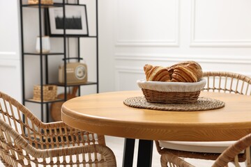 Aufkleber - Tasty croissants on table and wicker chairs in dining room. Interior design