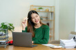 © ArLawKa - Ambitious Asian girl working from home Looking at laptop screen and smiling, checking mail or doing research while working remotely, online startup business, telemarketing