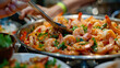 A close-up view of a pan filled with cooked shrimp and assorted ingredients, showcasing a delicious seafood dish.