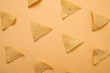 Tortilla chip or nacho chips pattern on yellow background, top view