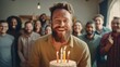 A man with a beard is holding a cake with candles and smiling