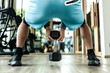 © Charnchai saeheng - A man doing squat exercises with dumbbell at gym. Fitness, workout and training concept.