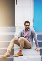 Poster - Man, building and serious on stairs for fashion, clothes and trendy with glasses outdoor in Cape Town, South Africa. Male person, gen z guy and vision for unique outfit, garment and urban style