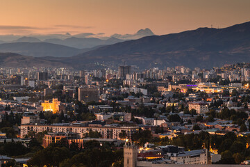 Wall Mural - View of Tbilisi from the surrounding hills. In the background you can see the Caucasus Mountains. A warm autumn day in the capital of Georgia.