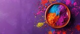Fototapeta  - A bowl of colorful powder is on a purple background. The bowl is filled with a variety of colors, including red, yellow, and blue. Concept of creativity and playfulness, as the colors are bright