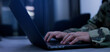 © chinnarach - close up solider man officer hand type command to check and control on monitoring program in dark operation room in military station for technology and security concept