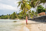 Fototapeta  - Mężczyzna w kąpielówkach na rajskiej plaży pod palmą