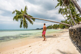 Fototapeta  - Mężczyzna w kąpielówkach na rajskiej plaży pod palmą
