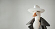 A duck wearing a hat and a coat. The duck is smiling and looking at the camera. a duck looking straight at the camera wearing a high fashion outfit and a white hat i a white background