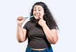 Girl suffering from gum pain holding toothbrush. Young woman with gingivitis holding toothbrush isolated. People holding toothbrush with gum problem