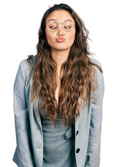 Sticker - Young hispanic girl wearing business clothes and glasses making fish face with lips, crazy and comical gesture. funny expression.