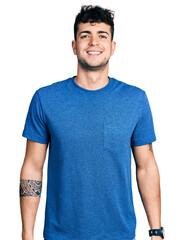 Wall Mural - Young hispanic man wearing casual t shirt with a happy and cool smile on face. lucky person.