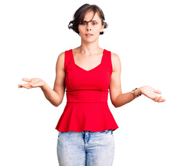 Canvas Print - Beautiful young woman with short hair wearing casual style with sleeveless shirt clueless and confused with open arms, no idea concept.