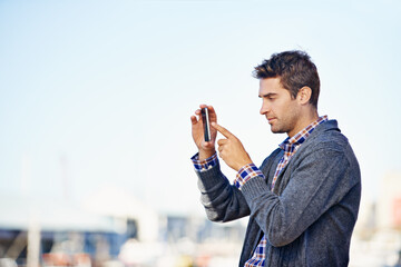 Poster - Man, phone and photography at harbor, outdoor and space for mockup with creativity on urban sidewalk. Person, photographer and smartphone for vacation, profile picture or memory on road in Cape Town