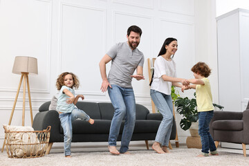 Wall Mural - Happy family dancing and having fun in living room, low angle view