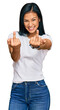 Beautiful hispanic woman wearing casual white tshirt showing middle finger doing fuck you bad expression, provocation and rude attitude. screaming excited