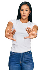 Wall Mural - Beautiful hispanic woman wearing casual white tshirt doing stop gesture with hands palms, angry and frustration expression