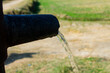 closeup of clear water coming out of hand pump