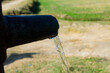closeup of clear water coming out of hand pump