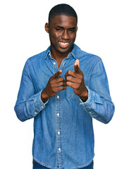 Wall Mural - Young african american man wearing casual clothes pointing fingers to camera with happy and funny face. good energy and vibes.