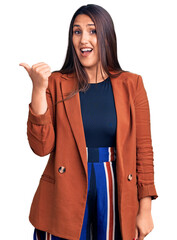 Poster - Young beautiful brunette woman wearing elegant clothes smiling with happy face looking and pointing to the side with thumb up.